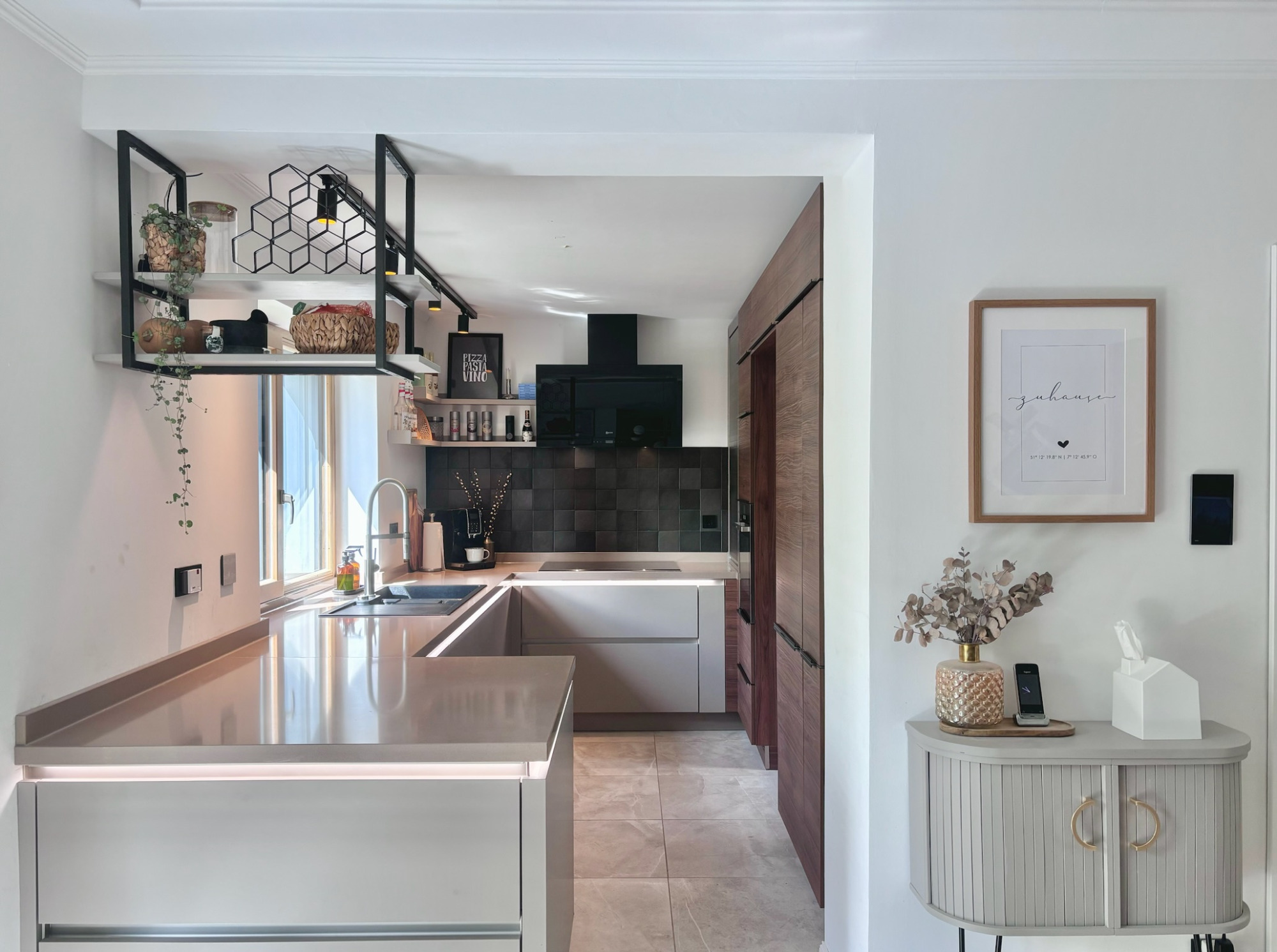 Küche - Projekt H9 Moderne Küche mit hellem Design, Holzverkleidung und eleganten Möbeln im Hintergrund.